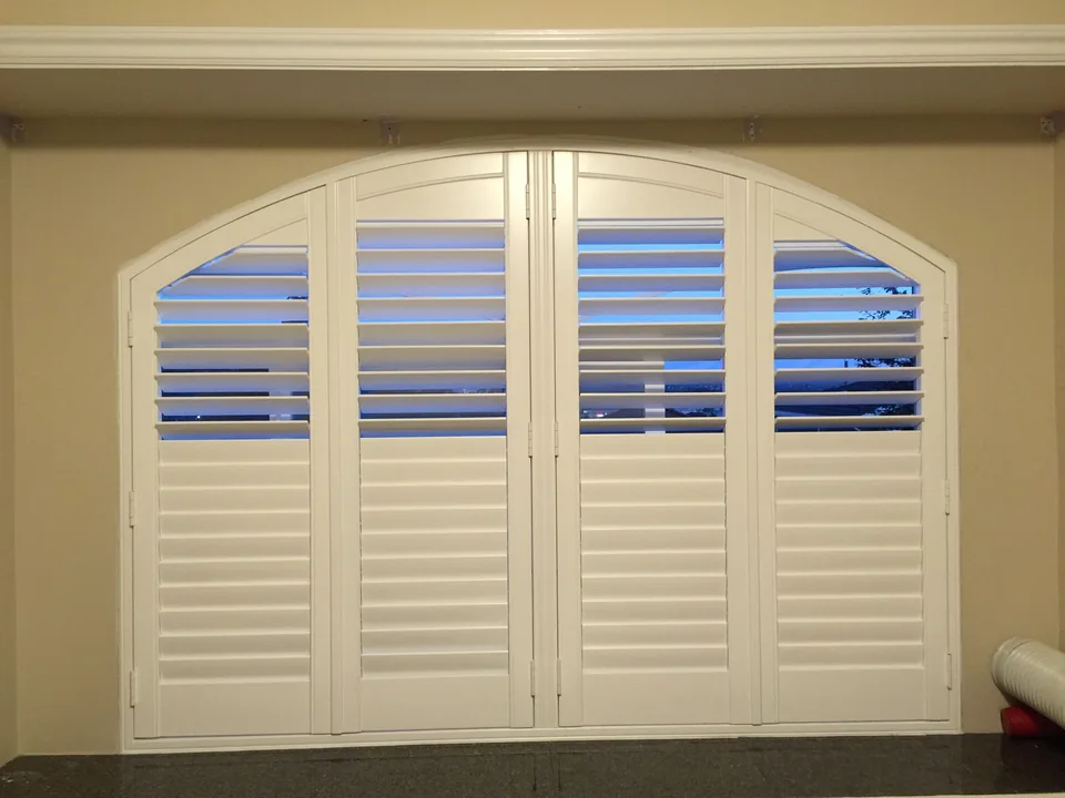 Shutter panels meeting a curved top